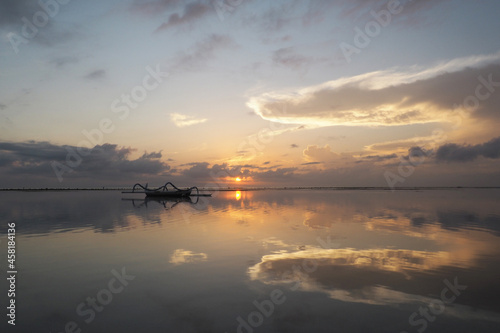 Beautiful morning  very calm  with reflection of sky on the water. Sanur Beach  Denpasar City  Bali Province  Indonesia