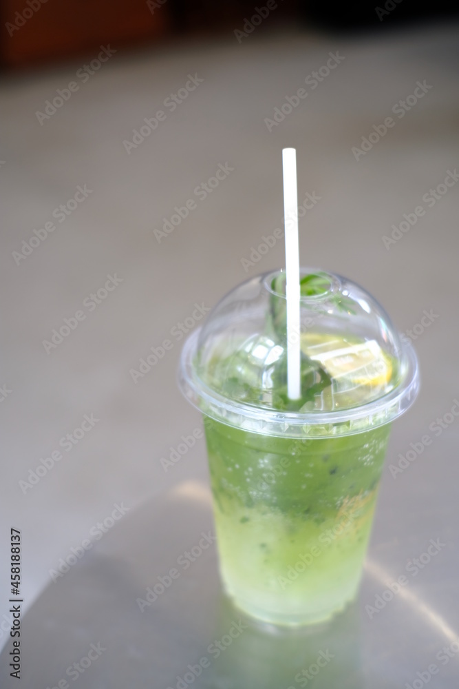 Iced matcha lemon soda on the table, Pouring green tea into a glass of honey lemon soda. Iced matcha lemon soda on the table, Pouring green tea into a glass of honey lemon soda.