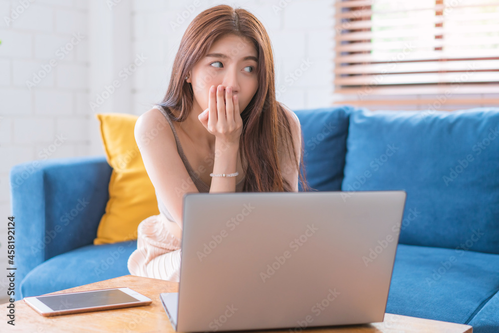 Fototapeta premium Asian woman relaxing sitting on sofa using computer notbeook at living room, Education technology and internet concept