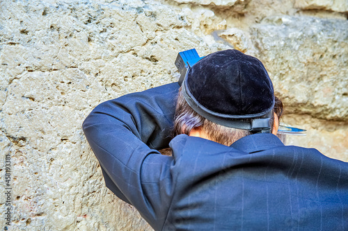 Orthodox Jewish man praying near the small Western-Wailing Wall, the holiest place in Judaism; Jerusalem Israel photo