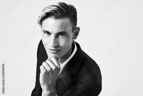 handsome man in a suit holds his hand near his face fashionable hairstyle black and white photo