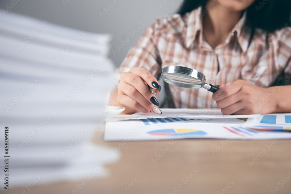 Fototapeta premium woman hand magnifier with graph
