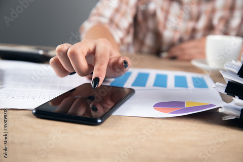 woman holding phone and chart report