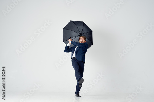 man in suit holding an umbrella in his hands elegant style weather rain photo