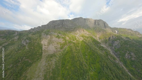 Ascend flight to mountain top rossnos with green forest in Norway during sunlight photo