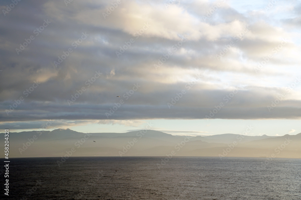 View of the coast of Morocco from the Atlantic Ocean. Sunrise. Morning. Clouds mountains horizon
