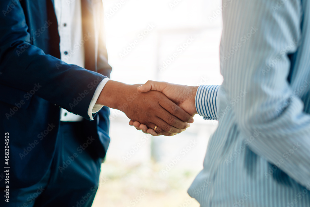 Two businessman shaking hands together after good deal connection to join investment business.