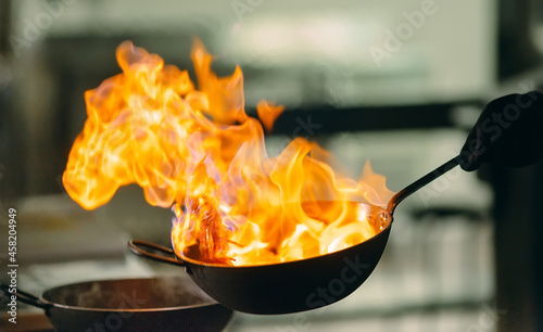 Modern kitchen. Cooks prepare meals on the stove in the kitchen of the restaurant or hotel. The fire in the kitchen.