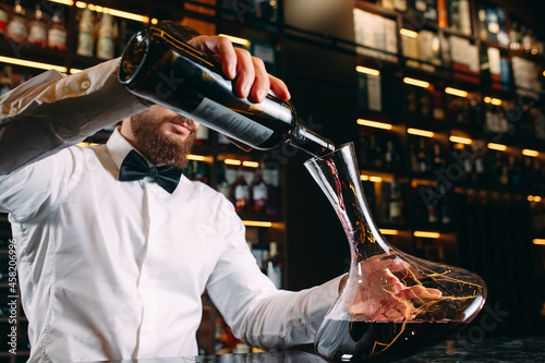 Fotografie, Obraz Young handsome man sommelier tasting red wine in cellar.