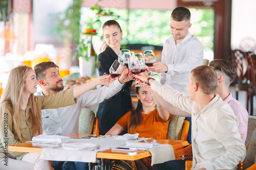 Friends drink wine on the terrace of the restaurant.