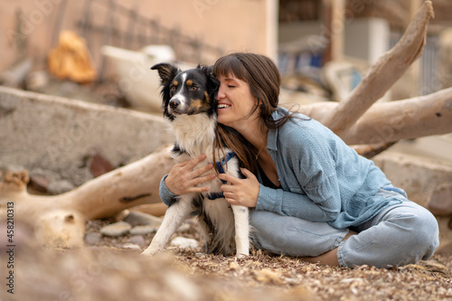 Caucasian girl with her border collie dog on the beach and smiling