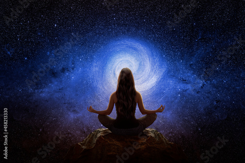 Woman with yoga pose in front of the universe photo