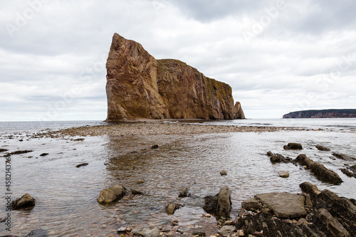 Side view of the famous limestone Percé Rock in the Gaspé peninsula seen at low tide during a  cloudy afternoon, Quebec, Canada