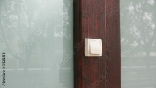 Fotografie Interruptor blanco en puerta de madera y cristal