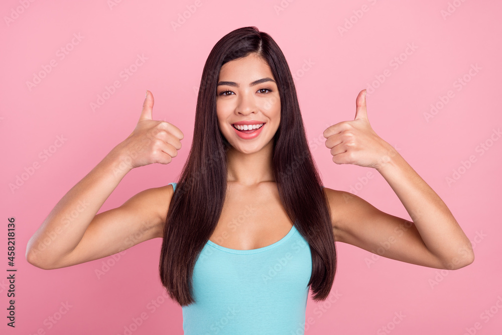 Photo portrait woman smiling showing thumb-up like sign isolated pastel pink color background