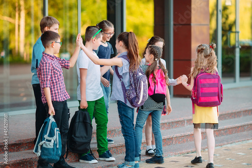 Schoolmates go to school. Students greet each other.