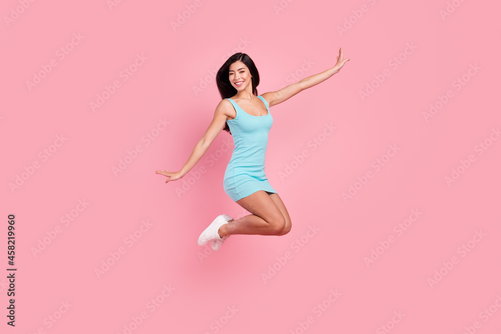 Full size profile photo of sweet young lady jump wear blue dress sneakers isolated on pink color background