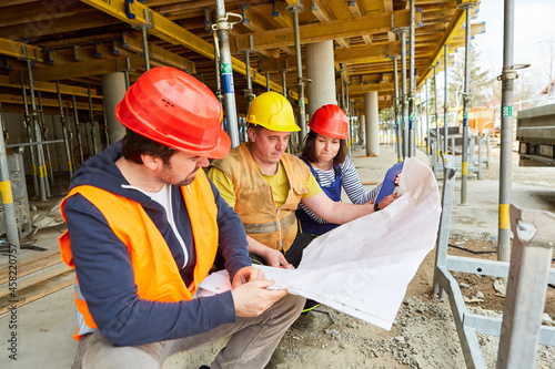 Handwerker und Architekten mit Bauzeichnung bei Hausbau