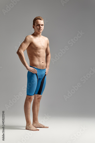 Young swimmer in excellent physical shape, on a gray background with copy space, call for sports, advertising banner