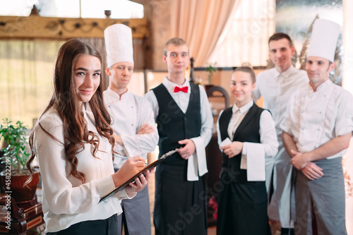 restaurant manager and his staff in kitchen. interacting to head chef in commercial kitchen.