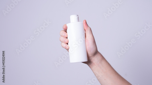 a man holding a bottle of lotion in his hand