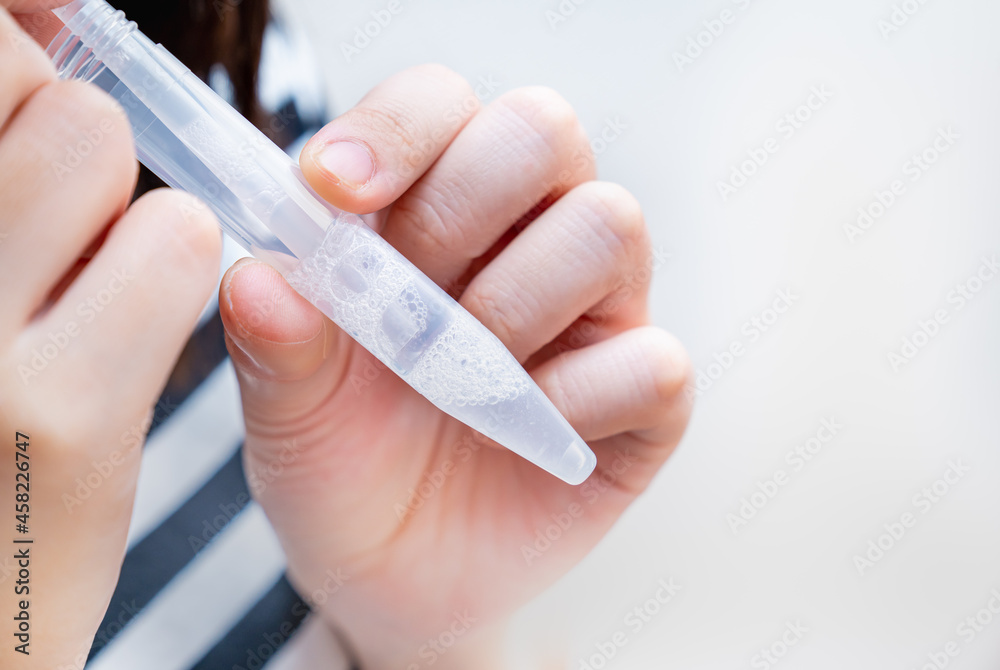 PCR検査キットを使用し、自宅で唾液を採取する女性の写真。PCR検査のイメージ。 - obrazy, fototapety, plakaty 