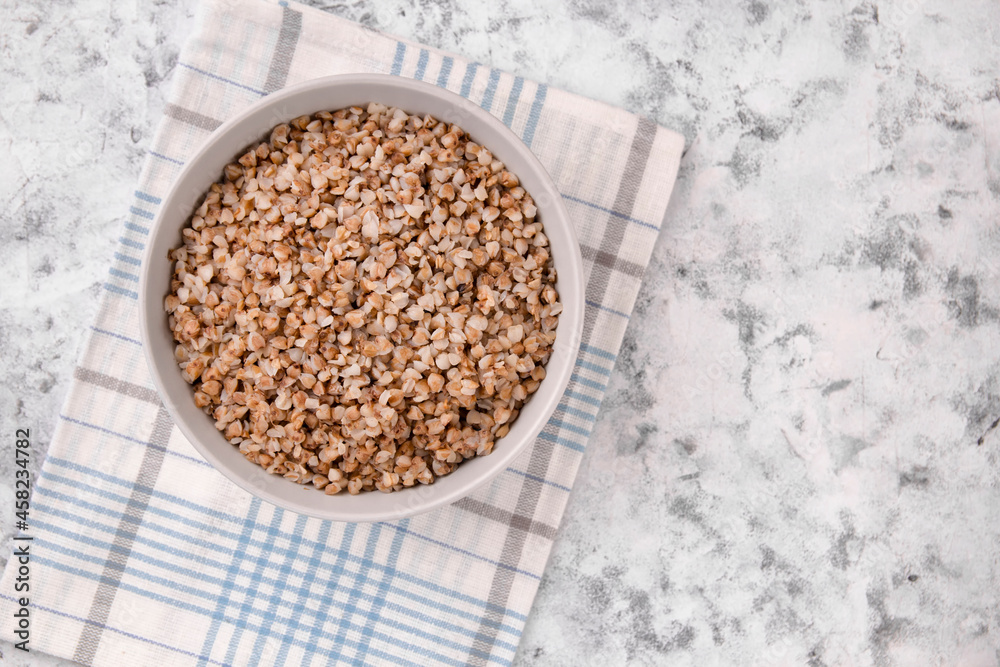 Freshly cooked buckwheat porridge in a plate on a gray background. Freshly cooked buckwheat porridge in a plate on a gray background.