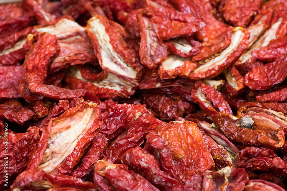Sun-dried tomatoes in a basket in a street food market, close up. Ripe tomatoes lose most of their water content after spending a majority of their drying time in the sun, close up Sun-dried tomatoes in a basket in a street food market, close up. Ripe tomatoes lose most of their water content after spending a majority of their drying time in the sun, close up