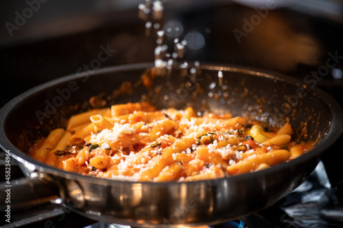 Cropped view of chef cooking Italian pasta with cheese, vegetable