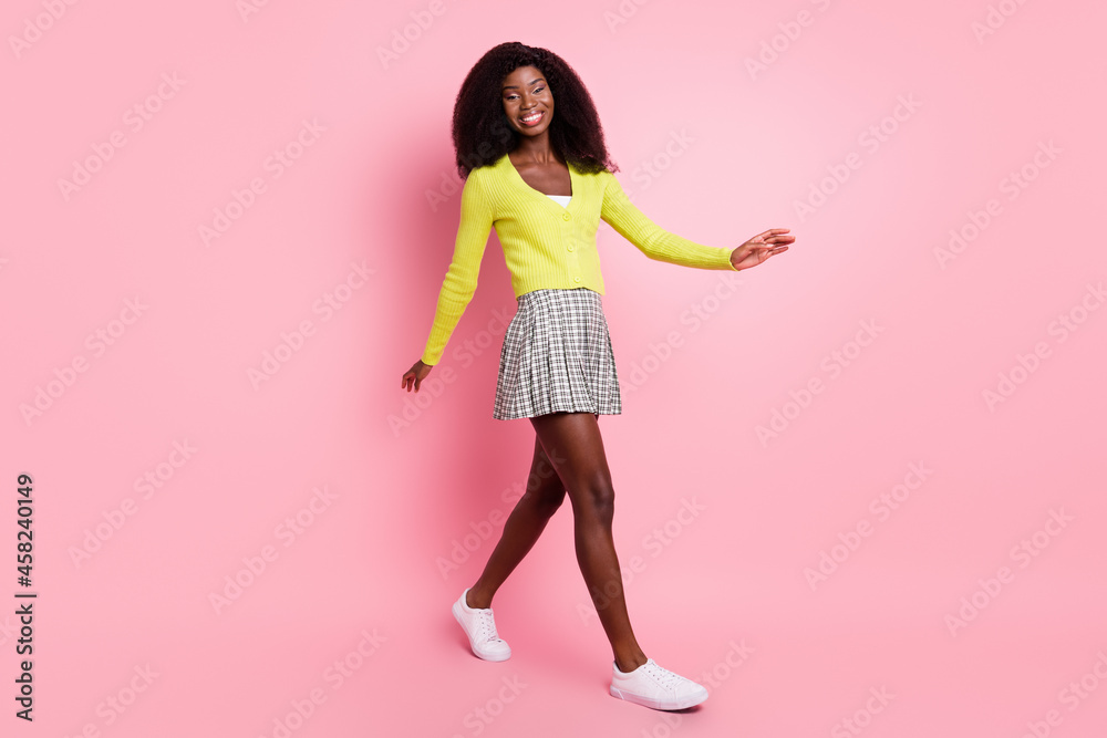 Full length profile portrait of pretty positive dark skin lady walking look camera isolate don pink color background Full length profile portrait of pretty positive dark skin lady walking look camera isolate don pink color background