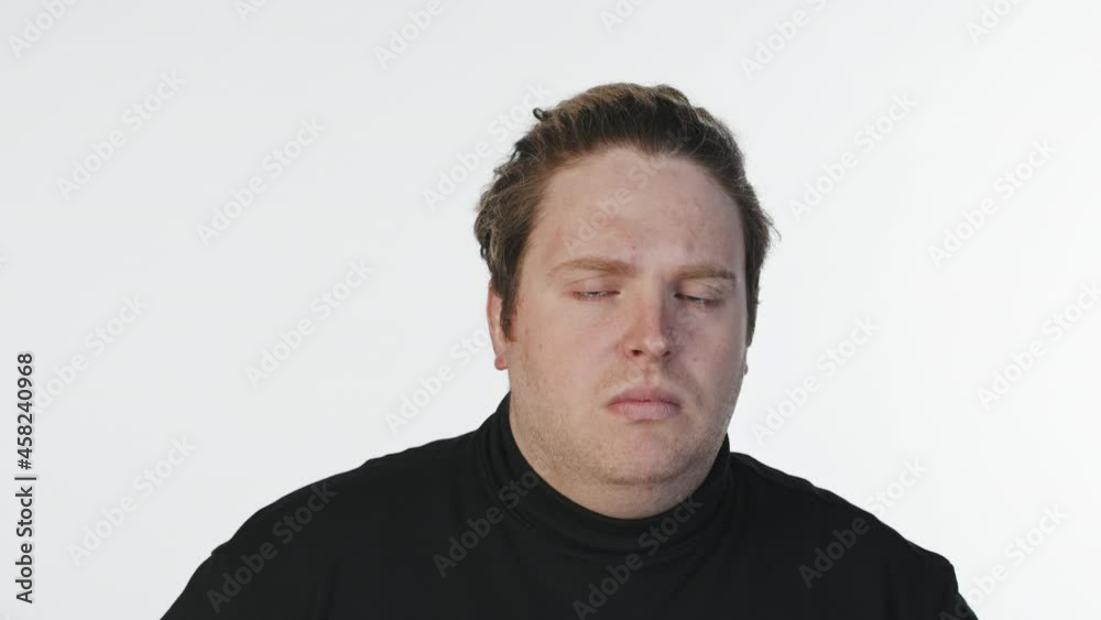 Medium close-up portrait with slowmo of young Caucasian man making OK face expression standing at white background in studio Medium close-up portrait with slowmo of young Caucasian man making OK face expression standing at white background in studio