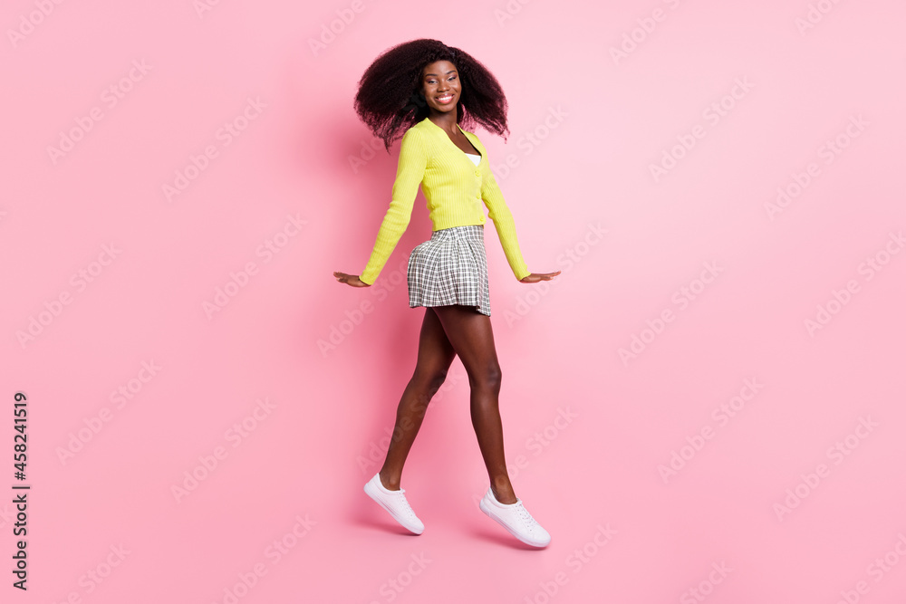 Full size profile side photo of young beautiful lovely cheerful positive afro girl go walk in air isolated on pink color background