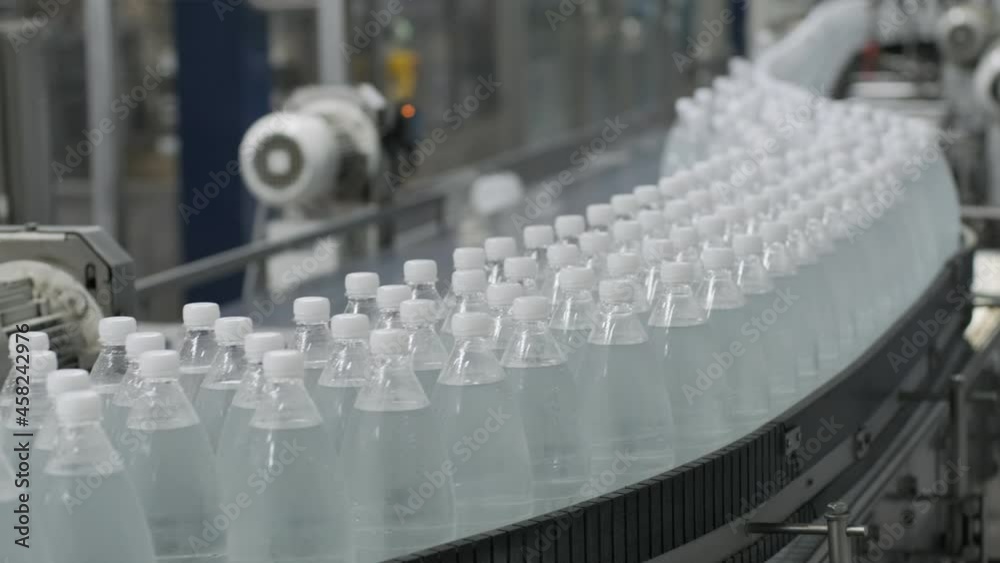 Conveyor belt with bottles of drinking water at a modern beverage plant Conveyor belt with bottles of drinking water at a modern beverage plant