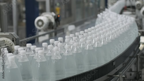 Conveyor belt with bottles of drinking water at a modern beverage plant