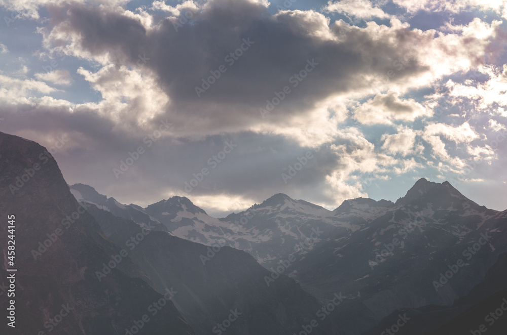 Beautiful sunset in the mountains. Mountain peaks of the Caucasus mountains in the rays of the evening sun.