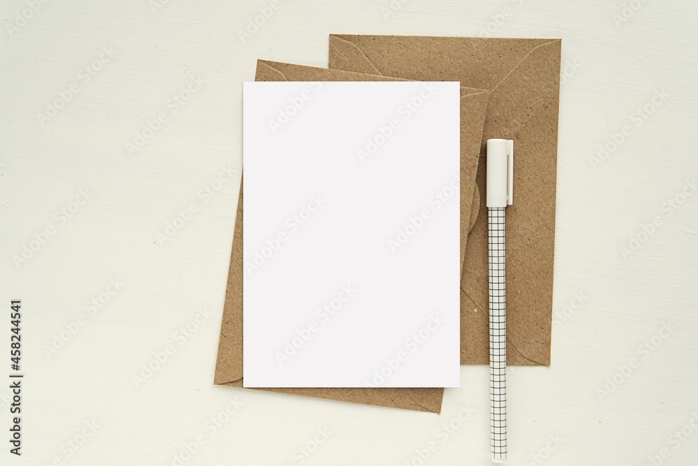 A6 size blank card mockup, brown kraft paper envelopes and pen