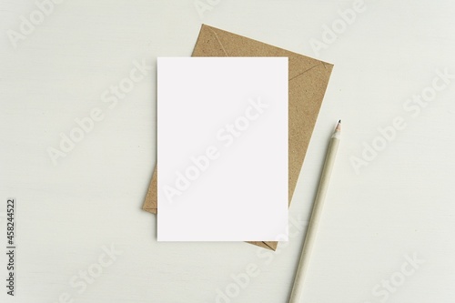 A6 card notecard, greeting card, postcard mockup for design presentation or text, brown envelope, pencil, minimal flat lay.