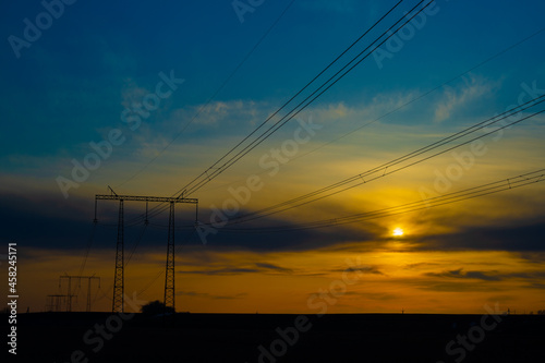 Electric high voltage pole at sunset background