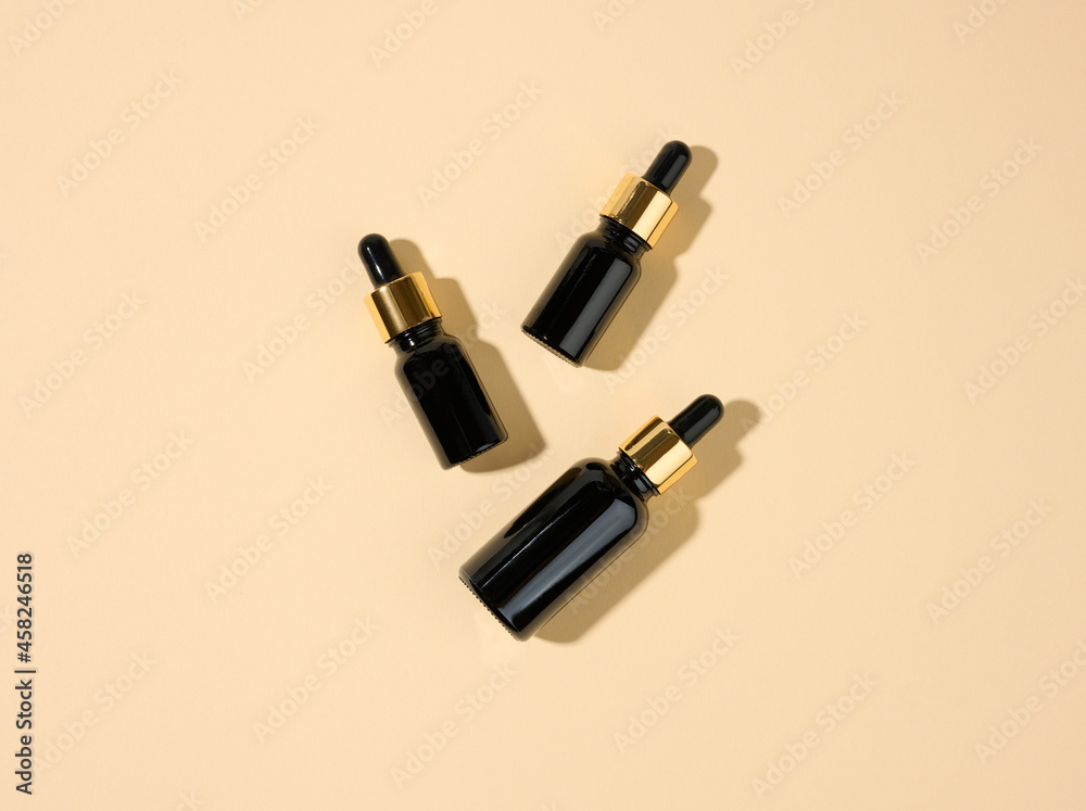 glass cosmetic brown bottles with a pipette on a beige background. Cosmetics SPA branding mockup, top view glass cosmetic brown bottles with a pipette on a beige background. Cosmetics SPA branding mockup, top view