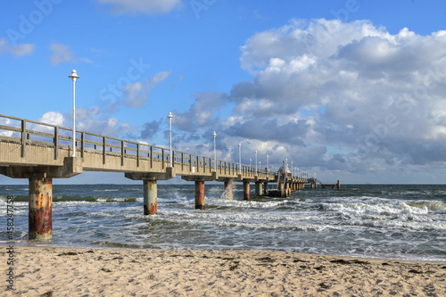 Seabridge at the beach in the tourist resort zinnowitz at the baltic sea  windy weather with waves on the water and blue sky with clouds  copy space