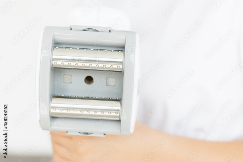Fototapeta premium The handle of the massage device. body massage. beauty salon. the maniple. Manipulator for lpg massage on the hands of a cosmetologist. Close-up view.
