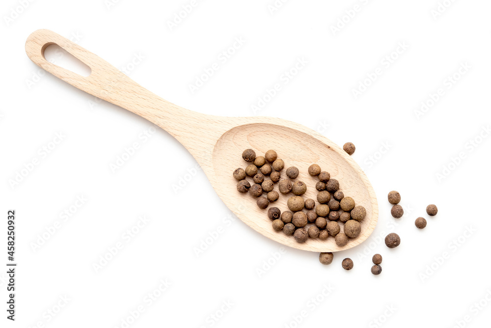 Spoon with allspice, grains of allspice or black pepper isolated on white. Scattered pepper, top view. Spoon with allspice, grains of allspice or black pepper isolated on white. Scattered pepper, top view.