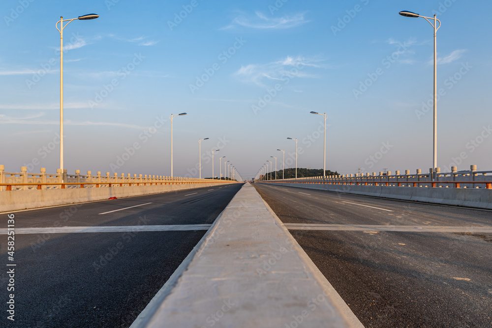 A straight road leading to the distance on a bridge