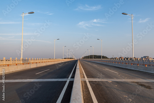 Canvas Print A straight road leading to the distance on a bridge