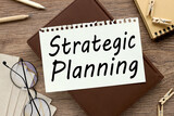 Business Strategic Planning. notepad page on notepad on wood table. with place for text. near office supplies and glasses