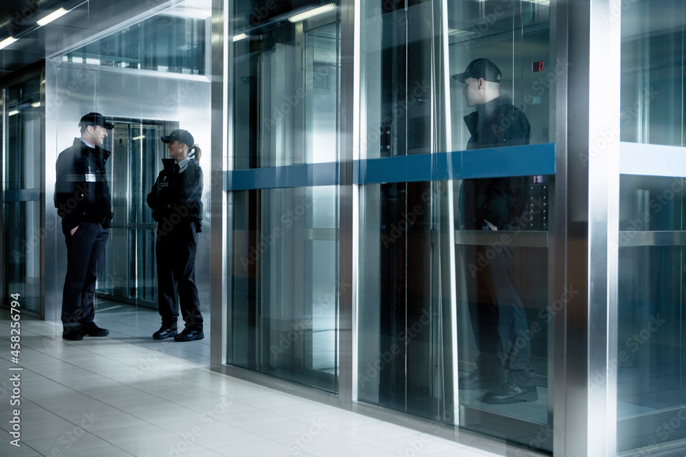 Security guards standing in corridor near elevator Security guards standing in corridor near elevator