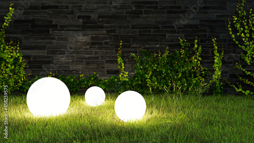 Drei Leuchtkugeln leuchten abends im Garten im Gras photo