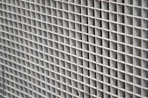 Metal grip grating surface, which is designed as safety guard part of power generator machine cooling system. Background texture object photo. Selective focus.