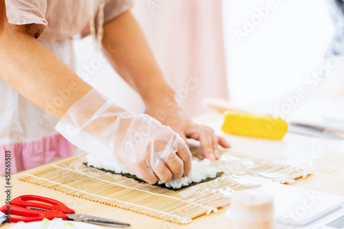 料理教室で巻き寿司を作る女性の手元