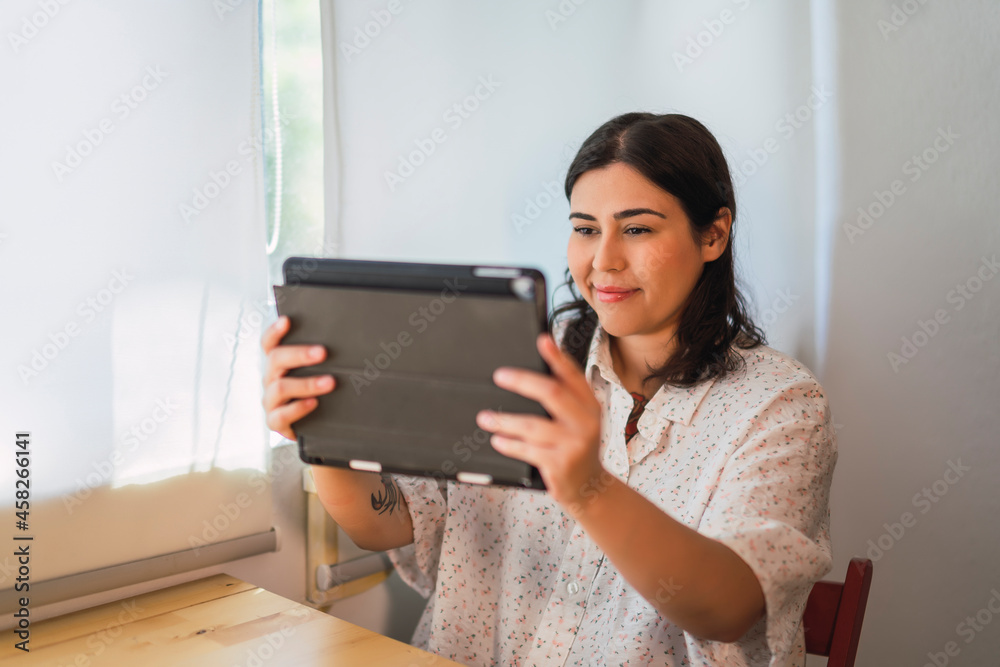 Chica joven risueña guapa interactuando con una tablet Chica joven risueña guapa interactuando con una tablet